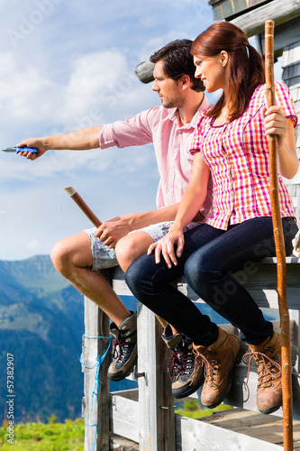 Photo: Alpen - Mann und Frau vor Almhütte in Bergen Alpen - Mann und Frau vor Almhütte in Bergen