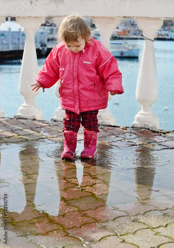 Photo: baby girl walking in puddle baby girl walking in puddle