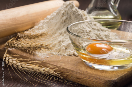 Photo: Baking ingredients with wheat ears on wood board Baking ingredients with wheat ears on wood board