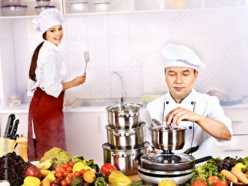 Photo: Man in chef hat and woman cooking . Man in chef hat and woman cooking .