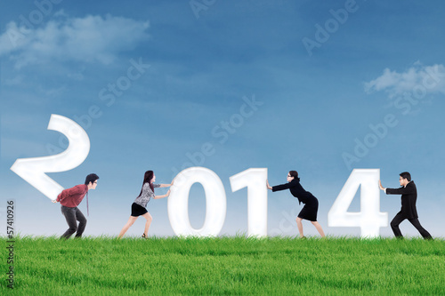 Photo: Businesspeople arrange new year 2014 outdoor Businesspeople arrange new year 2014 outdoor