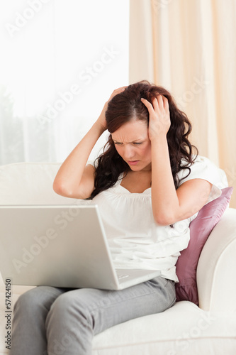Photo: Close up of a frustrated woman with a laptop Close up of a frustrated woman with a laptop
