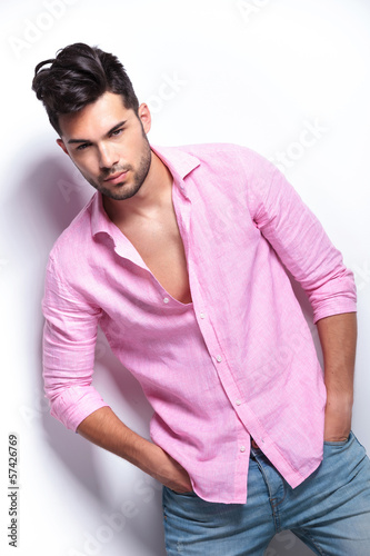Photo: young fashion man holds hands in pockets young fashion man holds hands in pockets