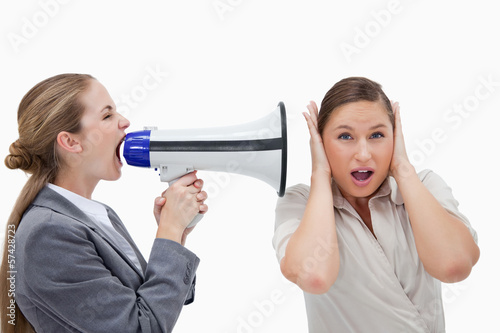 Photo: Businesswoman yelling at her coworker through a megaphone Businesswoman yelling at her coworker through a megaphone
