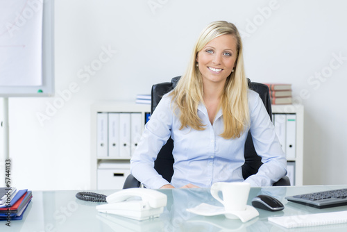 Photo: frau sitzt entspannt im büro frau sitzt entspannt im büro