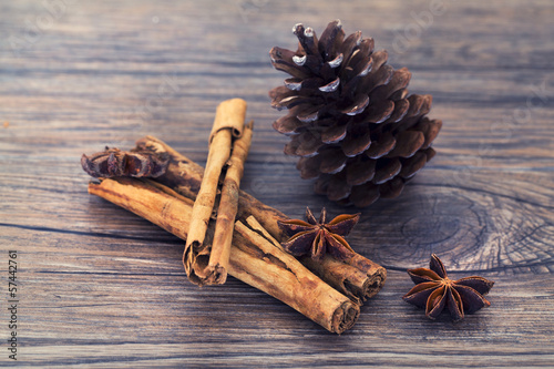 Photo: Star anise, cinnamon and pine cone on a wooden background Star anise, cinnamon and pine cone on a wooden background
