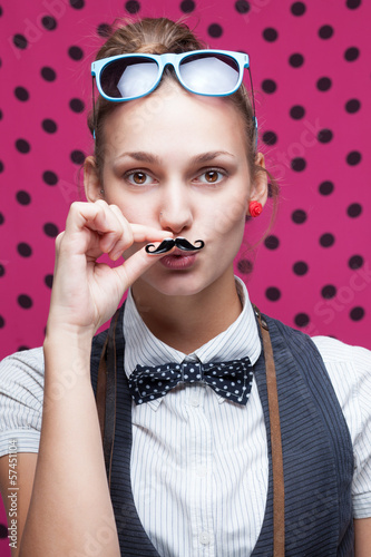 Photo: funny face of hipster style girl posing with mustache funny face of hipster style girl posing with mustache