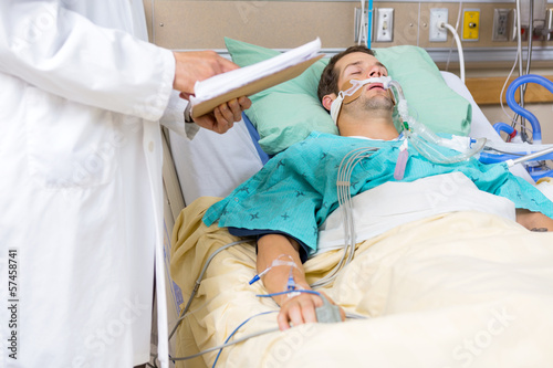 Photo: Doctor Examining Male Patient's Test Report Doctor Examining Male Patient's Test Report
