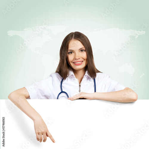 Photo: young woman doctor with a blank banner young woman doctor with a blank banner