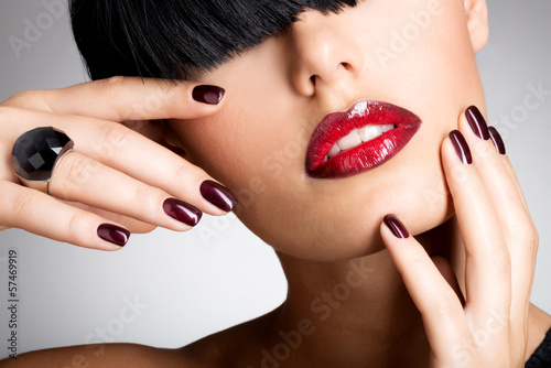 Photo: Closeup face of a woman with beautiful sexy red lips and dark na Closeup face of a woman with beautiful sexy red lips and dark na