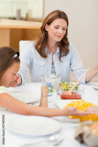 Photo: Praying family about to have dinner Praying family about to have dinner