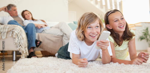 Photo: Siblings lying on the floor watching tv Siblings lying on the floor watching tv