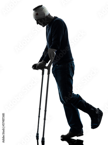 Photo: injured man walking sad with crutches silhouette injured man walking sad with crutches silhouette