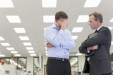 Photo: Bank manager talking to business owner with head in hands in hi-tech electronics factory Bank manager talking to business owner with head in hands in hi-tech electronics factory