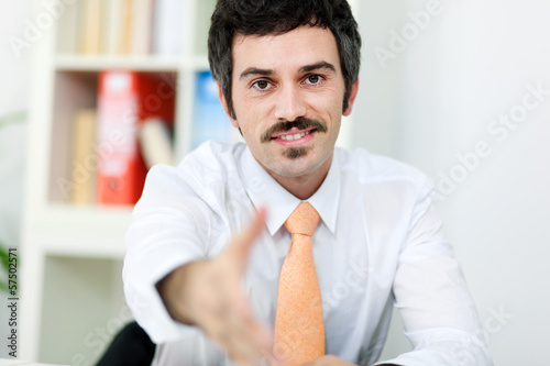 Photo: Smiling businessman giving hand for handshake Smiling businessman giving hand for handshake