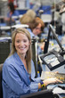Photo: Businesswoman with headset talking on telephone and using digital tablet near window Businesswoman with headset talking on telephone and using digital tablet near window