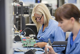 Foto: Technicians examining printed circuit boards in hi-tech electronics manufacturing plant Technicians examining printed circuit boards in hi-tech electronics manufacturing plant