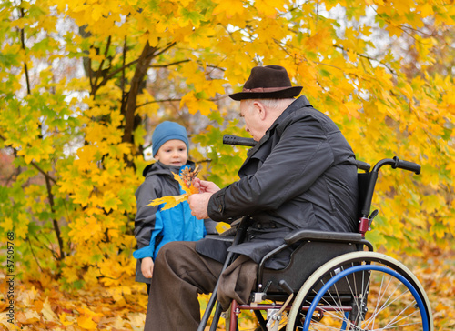 Photo: Elderly disabled man playing with his grandson Elderly disabled man playing with his grandson