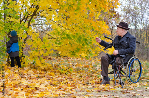Photo: Disabled grandfather and grandchild outdoors playing Disabled grandfather and grandchild outdoors playing