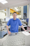 Photo : Portrait of smiling technician with aluminum products in hi-tech manufacturing plant Portrait of smiling technician with aluminum products in hi-tech manufacturing plant