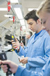 Photo: Worker examining machine parts in bin on production line in distribution warehouse Worker examining machine parts in bin on production line in distribution warehouse