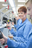 Photo: Portrait of smiling technician using electric screwdriver to assemble machine part in manufacturing plant Portrait of smiling technician using electric screwdriver to assemble machine part in manufacturing plant