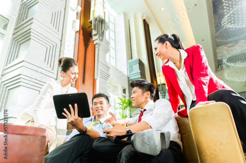 Photo: Asian Chinese business people meeting in hotel lobby Asian Chinese business people meeting in hotel lobby
