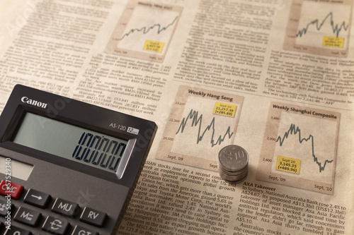 Photo: Newspaper stock market with calculator and money Newspaper stock market with calculator and money