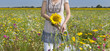 Photo: Portrait of smiling girl holding bunch of balloons among wildflowers in sunny meadow Portrait of smiling girl holding bunch of balloons among wildflowers in sunny meadow