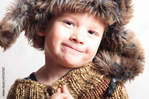 Photo: funny smiling child in fur hat.fashion.winter style.children funny smiling child in fur hat.fashion.winter style.children