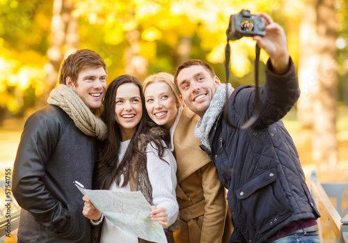Photo: group of friends with photo camera in autumn park group of friends with photo camera in autumn park