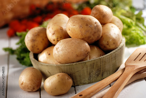 Photo: mucchio di patate nella ciotola di legno mucchio di patate nella ciotola di legno