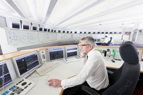 Photo: Engineers at computers in control room of nuclear power station Engineers at computers in control room of nuclear power station