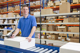 Photo: Portrait of smiling worker scanning boxes on production line in distribution warehouse Portrait of smiling worker scanning boxes on production line in distribution warehouse