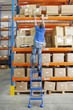 Photo: Portrait of smiling worker holding scanner and box at production line in distribution warehouse Portrait of smiling worker holding scanner and box at production line in distribution warehouse