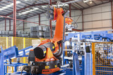 Photo: Robotic machinery lifting steel fencing on production line in manufacturing plant Robotic machinery lifting steel fencing on production line in manufacturing plant