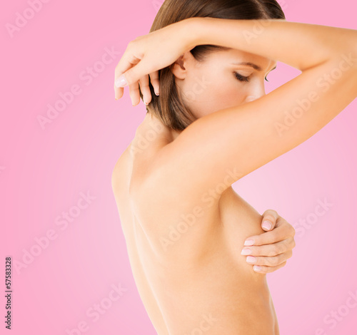 Photo: woman checking breast for signs of cancer woman checking breast for signs of cancer