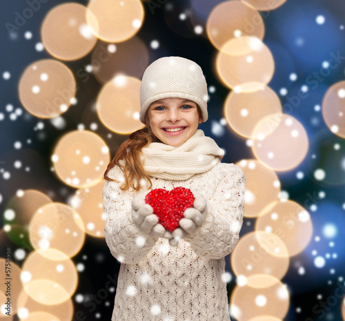 Photo: girl in winter clothes with small red heart girl in winter clothes with small red heart