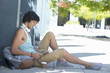 Photo: Young man with backpack, coffee cup and headphones using digital tablet on sidewalk Young man with backpack, coffee cup and headphones using digital tablet on sidewalk