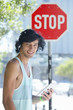 Foto: Portrait of smiling young man wearing headphones and using digital tablet near stop sign in city Portrait of smiling young man wearing headphones and using digital tablet near stop sign in city