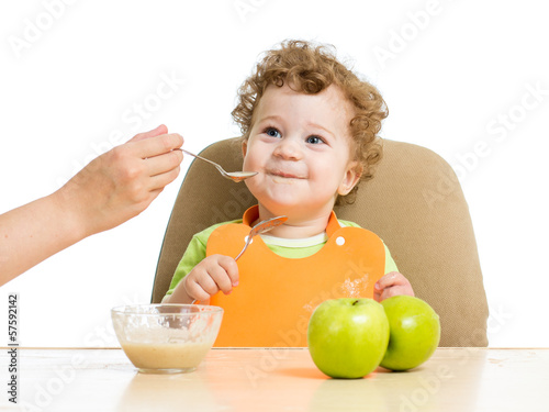 Photo: mother hand spoon feeding baby boy mother hand spoon feeding baby boy