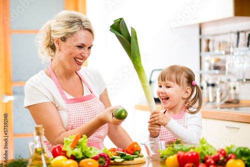Photo: mother and kid preparing healthy food and having fun mother and kid preparing healthy food and having fun
