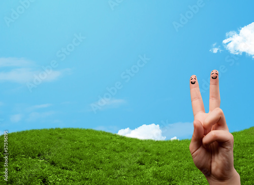 Photo: Cheerful finger smileys with landscape scenery at the background Cheerful finger smileys with landscape scenery at the background