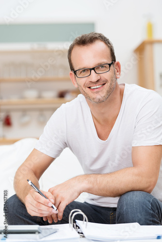Photo: mann mit aktenordner und taschenrechner zu hause mann mit aktenordner und taschenrechner zu hause