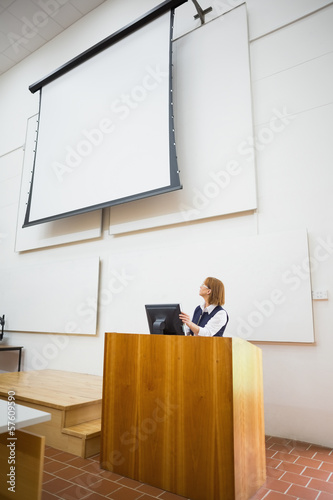 Photo: Teacher with computer and projection screen in lecture hall Teacher with computer and projection screen in lecture hall