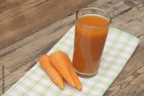 Photo: Glass of carrot juice and carrots on colorful napkin Glass of carrot juice and carrots on colorful napkin