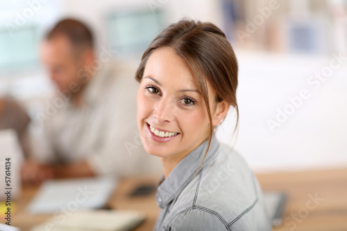 Photo: Young woman attending business training class Young woman attending business training class