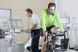 Foto: Sports scientist at computer and cyclist with mask on exercise bike in laboratory Sports scientist at computer and cyclist with mask on exercise bike in laboratory