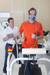 Photo: Sports scientist with digital tablet monitoring runner with mask on treadmill in laboratory Sports scientist with digital tablet monitoring runner with mask on treadmill in laboratory