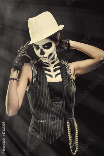 Photo: Woman with skeleton face art over black background Woman with skeleton face art over black background